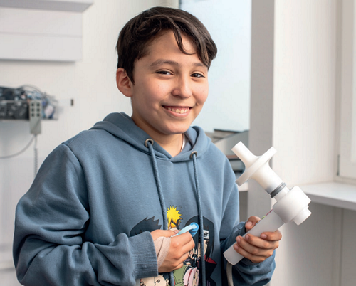 Garçon avec une chambre d'inhalation à la main