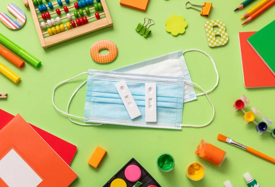 masque sur une table avec des jeux scolaires