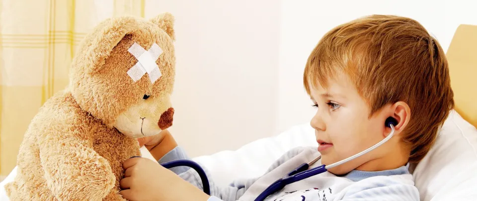 enfant tenant un ours en peluche